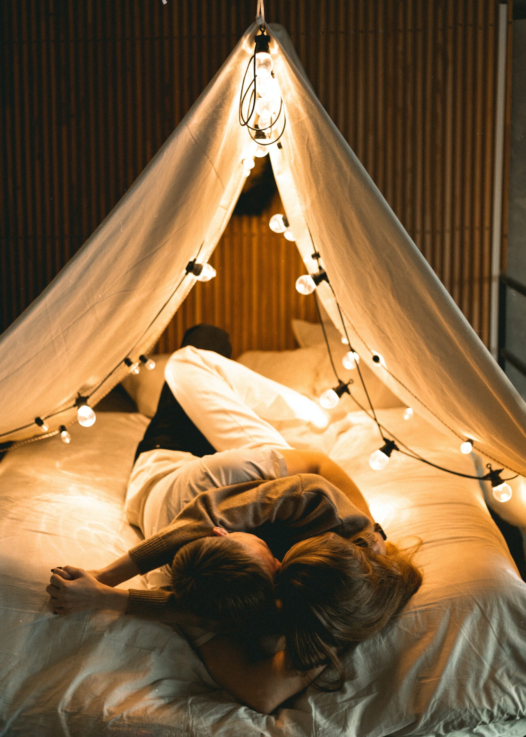 Couple cuddling on bed under canopy